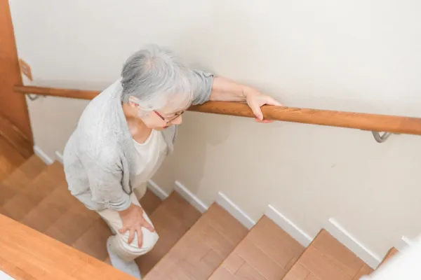 手すりにつかまって階段を登る様子